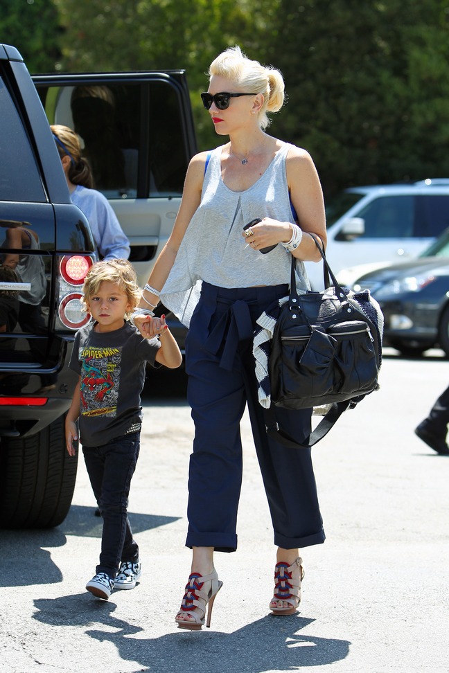Gwen Stefani white tank top, blue pants cuffed, sunglasses, black bag, high heels